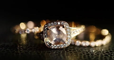 Anillo de oro con un gran brillante y varios anillos de oro con brillantes detrás
