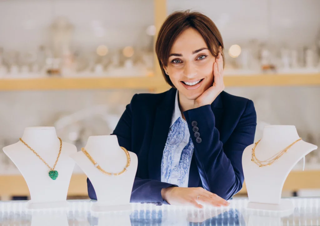 Mujer formal mostrando joyería sobre un mostrador de cristal